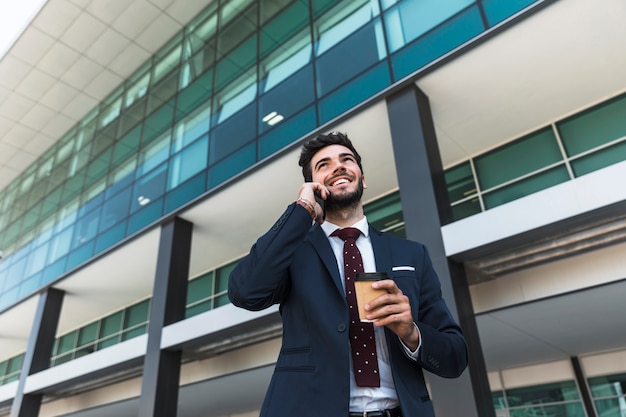 low angle smiley lawyer with phone coffee 23 21482307561